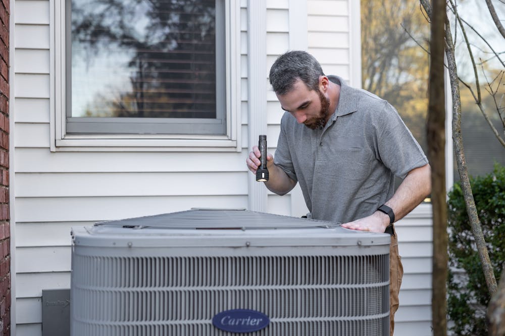 a man looking at the inside of an air conditioner